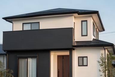 チャコールと明るい外壁のツートンカラーに塗り替えた現代的な戸建て住宅