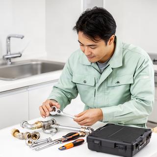 水回り設備を点検する担当者が工具を整える様子